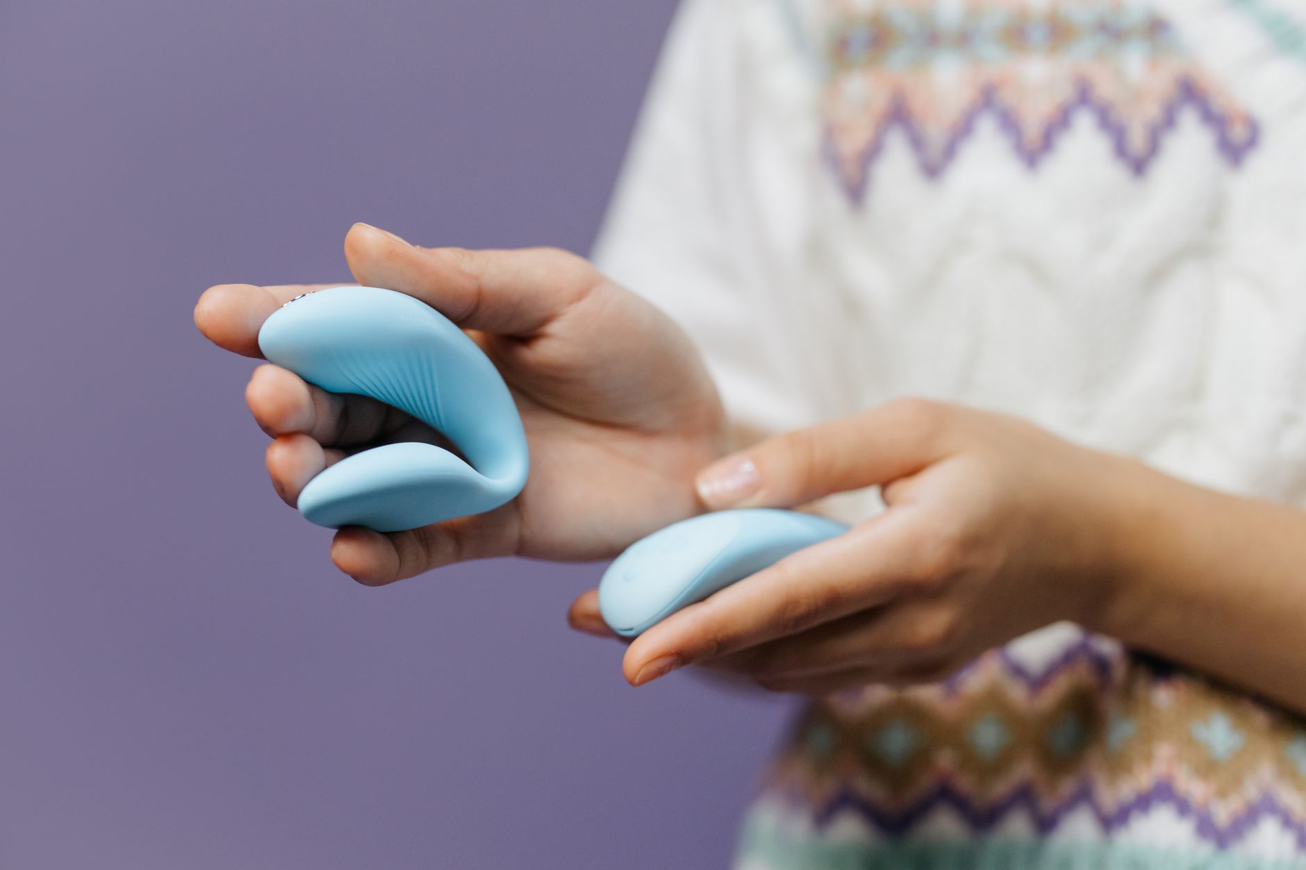 A close-up of hands holding a sleek lemon-colored vibrator against a purple background, symbolizing the return of pleasure.