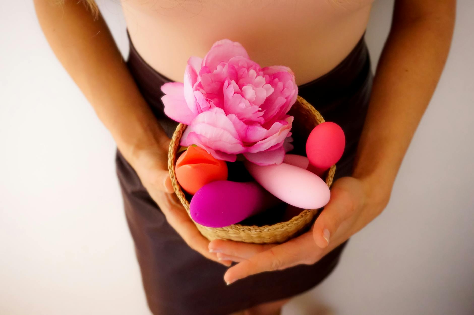 Hands holding pastel-colored silicone toys in soft light, representing new beginnings